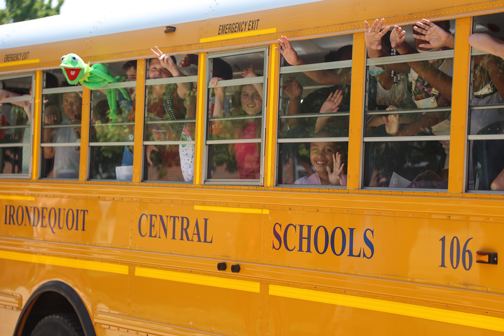 Students on a bus waving