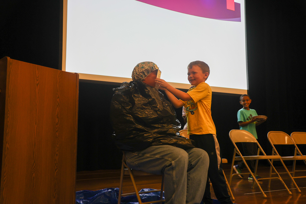 Student putting pie in Mr. Roach's face