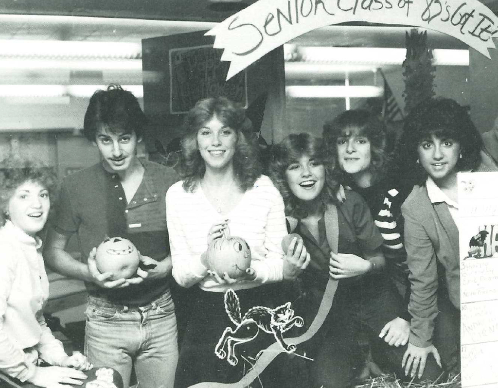 Class of 1983 seniors hold up the pumpkins they decorated.