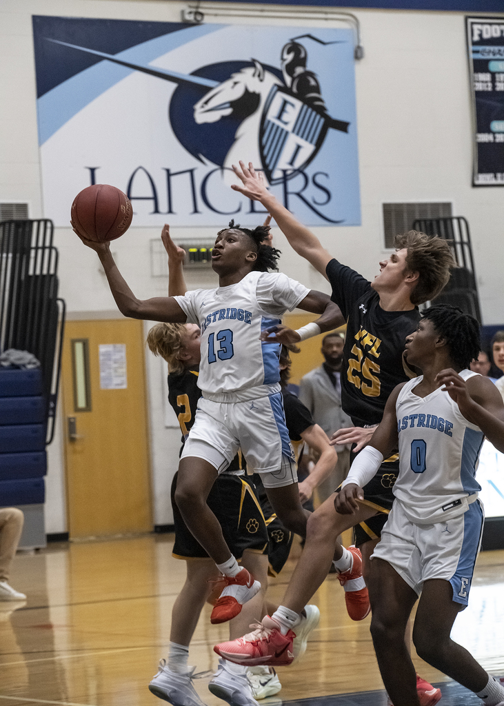 #13 on EI boys varsity going for a layup in basketball game