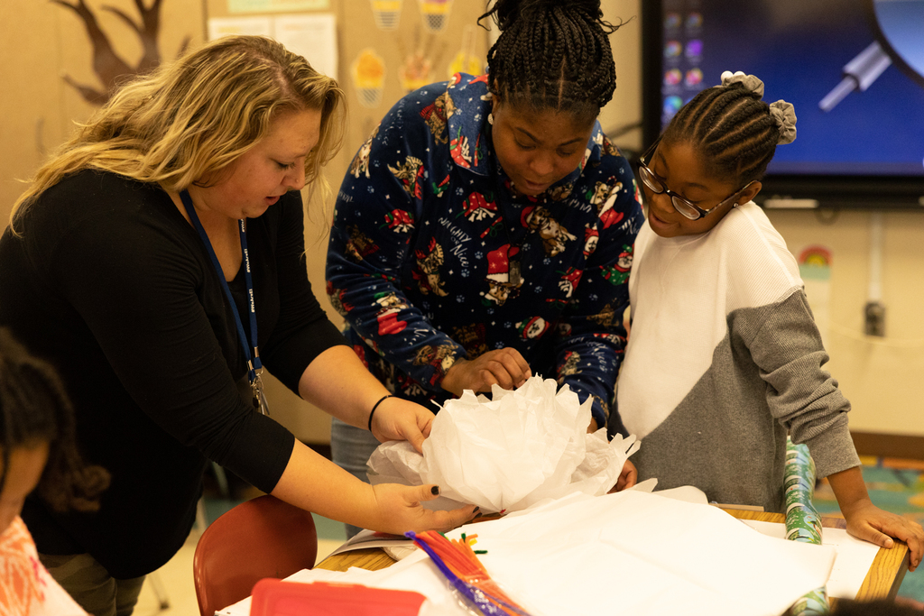 Ms. Pers and students making a white flower