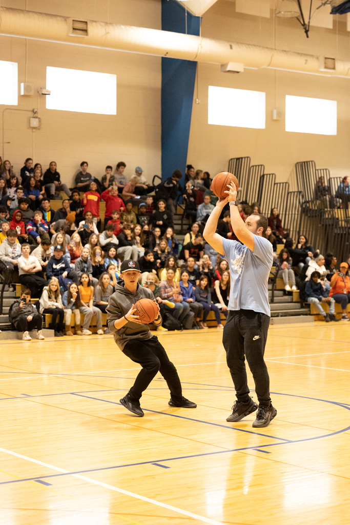 student and staff playing basketball