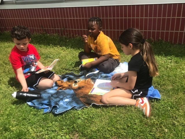 Students reading outside on a nice day.